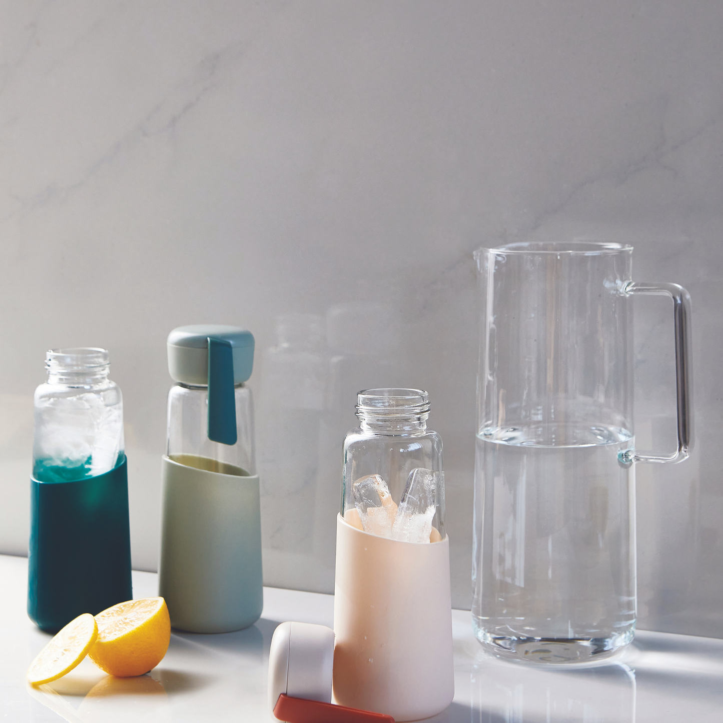 three tumblers next to a pitcher