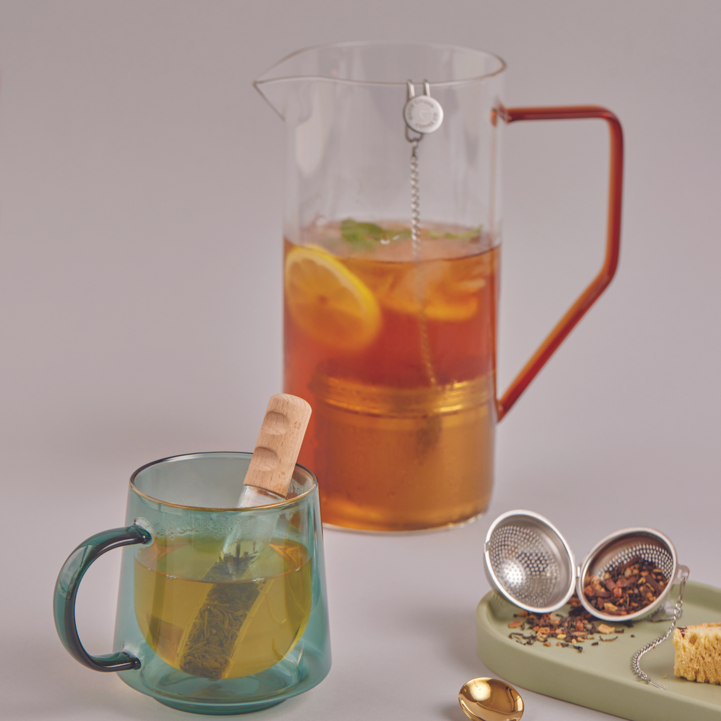 a cup of tea next to a pitcher of tea
