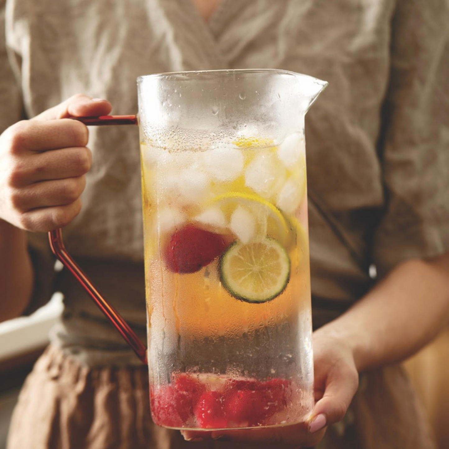 person holding a pitcher full of tea