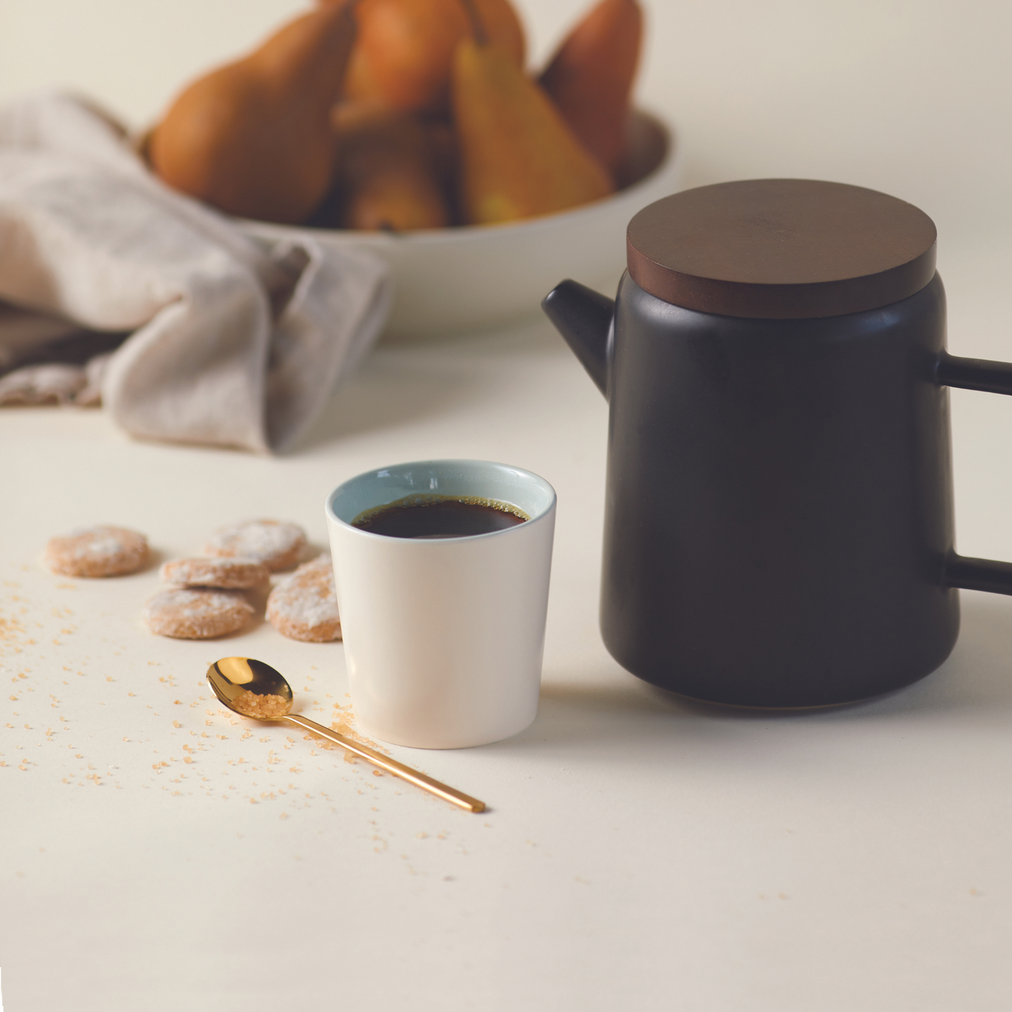spoon next to pour over with a cup of coffee