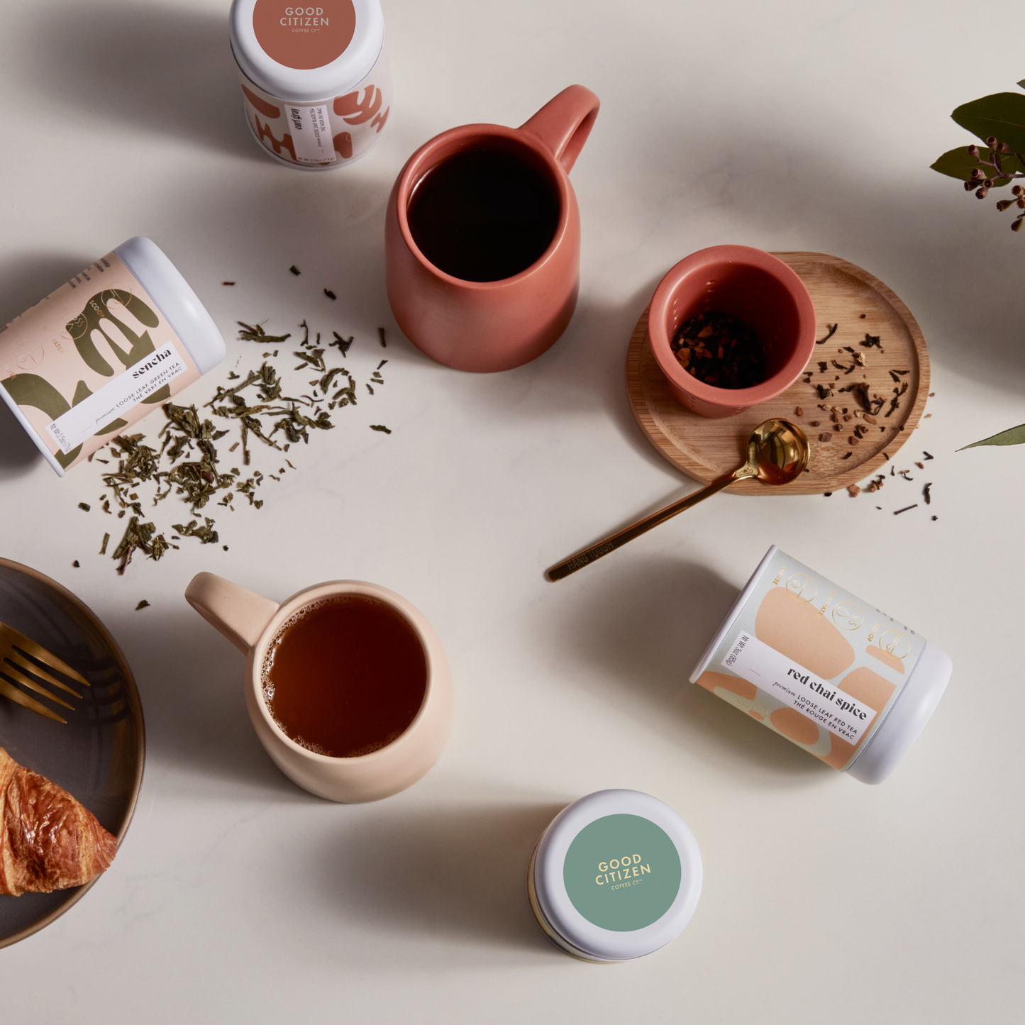 mugs with tea in it and around it