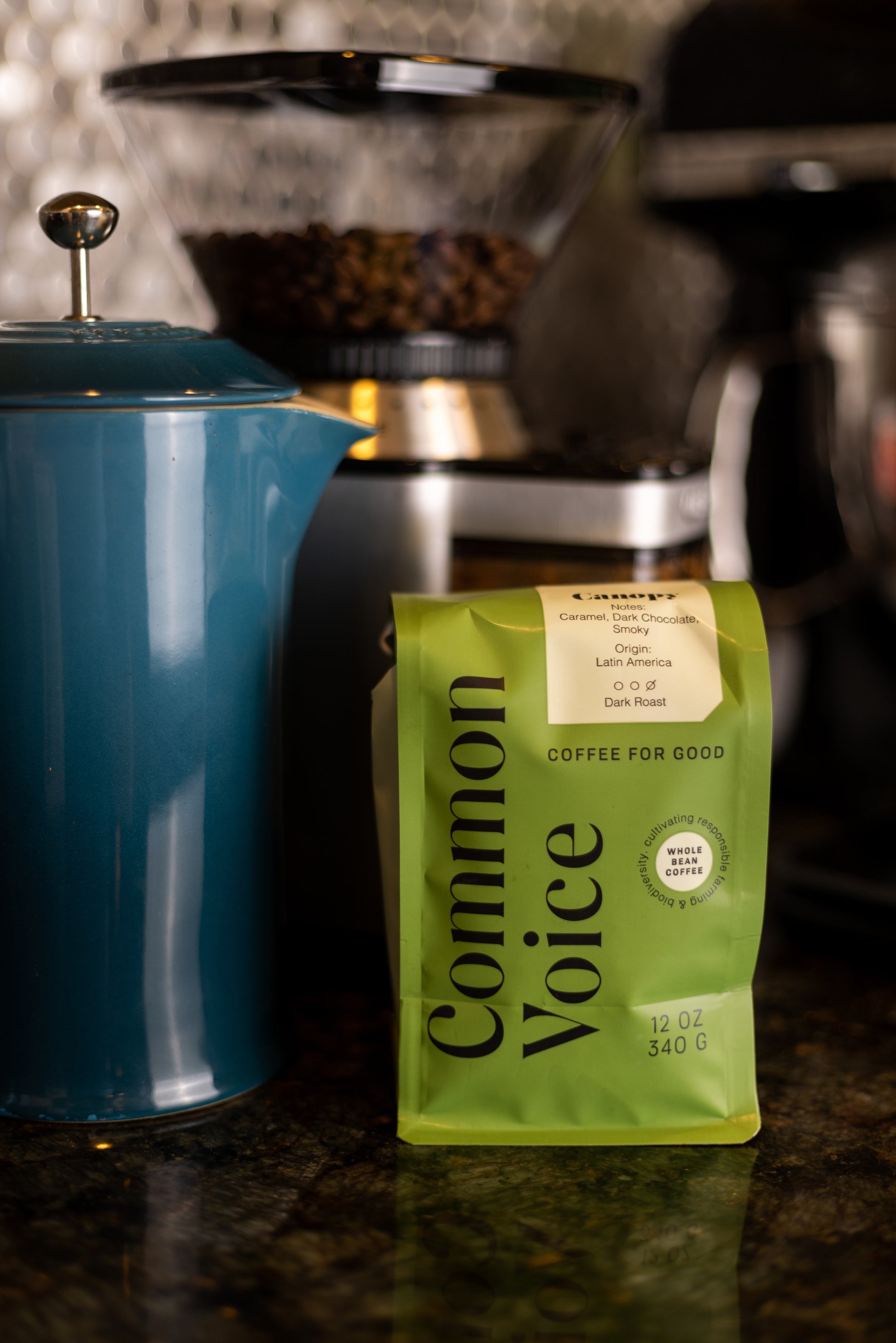 Common Voice Canopy coffee bag next to a coffee grinder and coffee pot