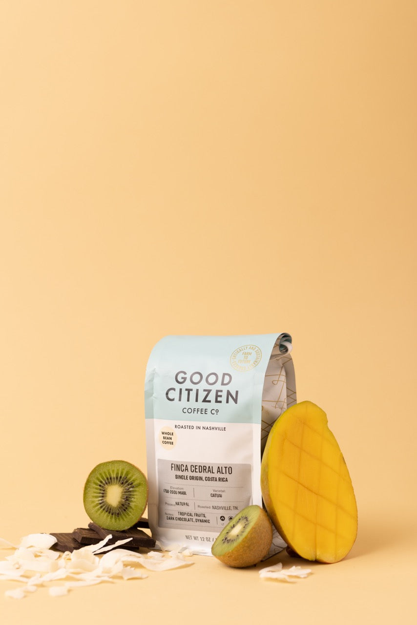 coffee bag with mango, kiwi, and coconut around it
