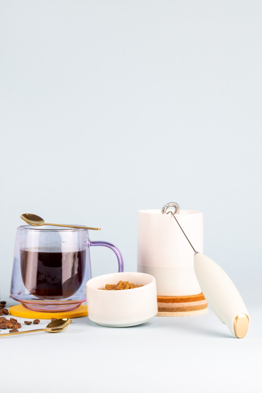 mug filled with coffee and cream set next to it